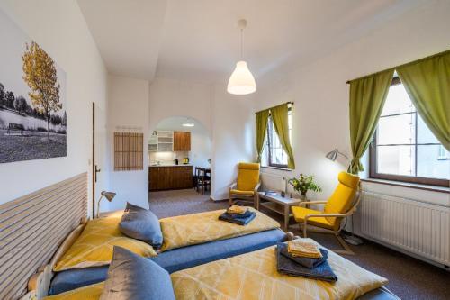 a bedroom with a bed and a living room at Apartmány U Parku in Vrchlabí