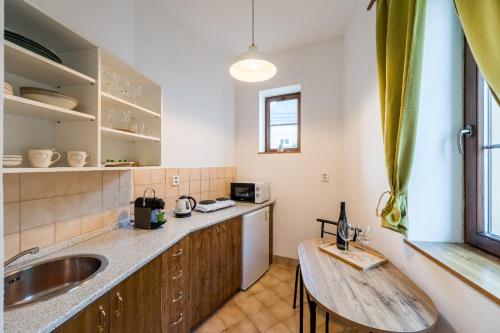 a kitchen with a sink and a table in it at Apartmány U Parku in Vrchlabí