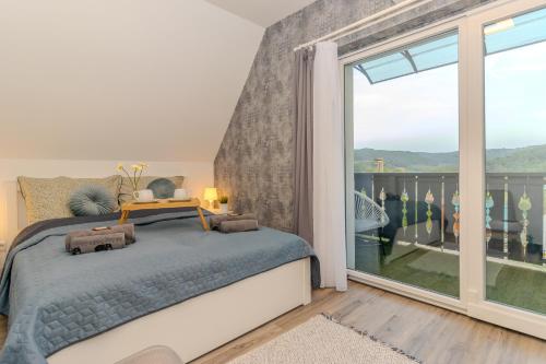 a bedroom with a bed and a large window at Panorámaház Bükkszék in Bükkszék