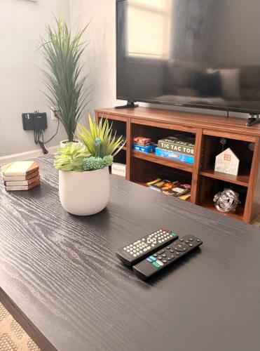 a remote control sitting on a table with a tv at Cozy 2 Bdrm Cottage King bed in Portsmouth