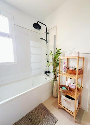 a bathroom with a shower and a shelf with a plant at Limon Home in Benacazón