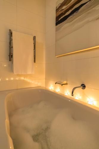 a bath tub with lights in a bathroom at #1202 Cartwright - Bold & Stylish in Cape Town