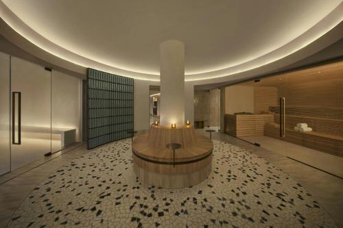 a large lobby with a large circular table in the middle at The Lake Como EDITION in Griante Cadenabbia