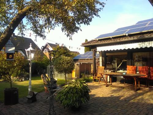 eine Terrasse mit einem Tisch und einem Haus in der Unterkunft Fewo Hansemann 1 in Alpen