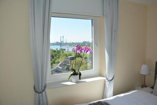 a window with a vase with a flower in it at Luxury apartment in Düsseldorf near trade fair in Düsseldorf