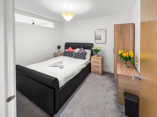 a bedroom with a black bed with flowers on it at Flat 2 - Luxury Bolton City Centre Apartments in Bolton