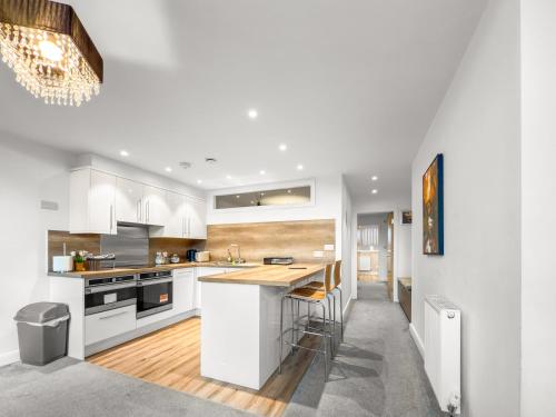 a kitchen with white cabinets and a wooden counter top at Flat 2 - Luxury Bolton City Centre Apartments in Bolton