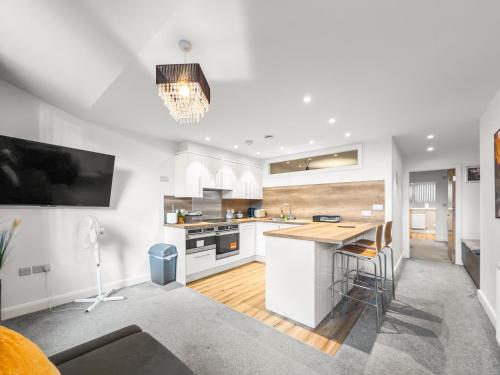 a kitchen with white cabinets and a wooden counter top at Flat 2 - Luxury Bolton City Centre Apartments in Bolton