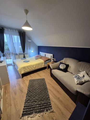 a living room with a couch and a bed at Dom pod flagą in Sobącz