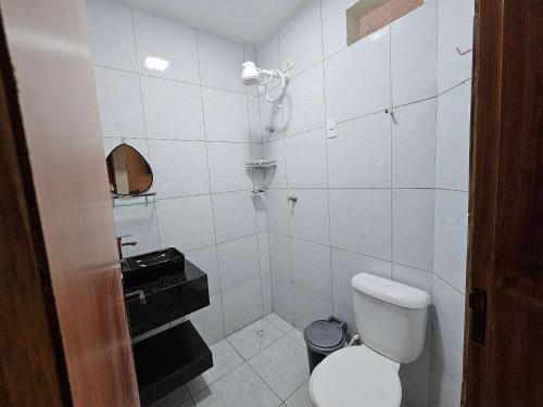 a white bathroom with a toilet and a sink at Maria Bonita Apartment | Cozy, 10 minutes from the city center in Caruaru