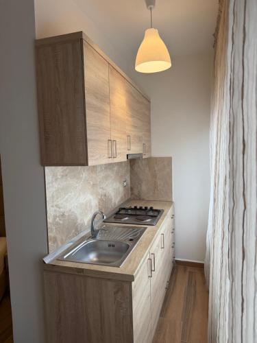 a kitchen with a sink and a stove in it at Blumont aparthotel durres in Durrës
