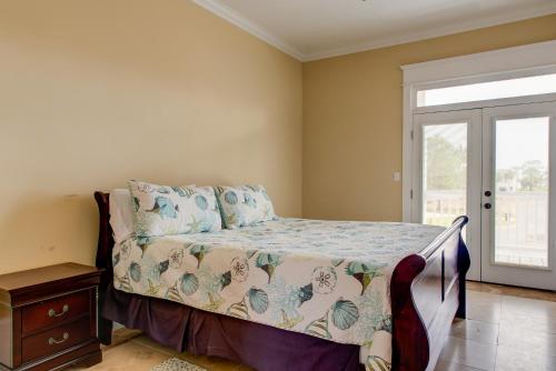 a bedroom with a bed and a window at Purple Parrot - 200 Lenora Ct in Dauphin Island