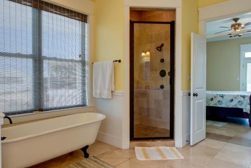 a bathroom with a bath tub and a shower at Purple Parrot - 200 Lenora Ct in Dauphin Island