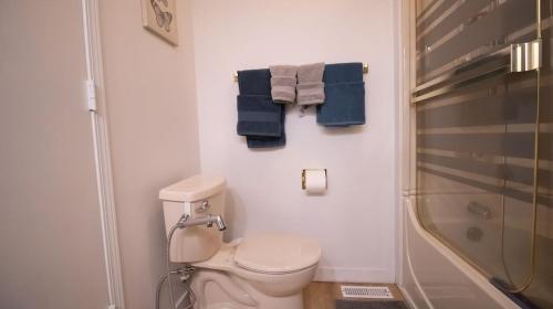 a bathroom with a toilet and a shower and towels at 3 cozy bedrooms 2 bathrooms in Winnipeg
