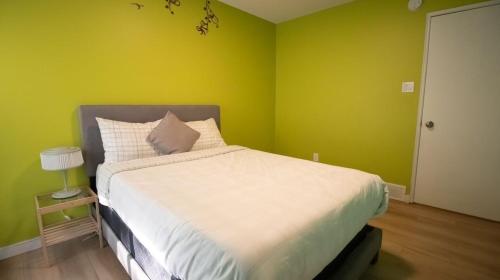 a bed in a room with a green wall at 3 cozy bedrooms 2 bathrooms in Winnipeg