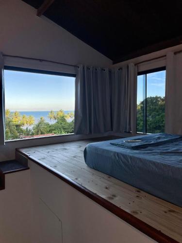 a bedroom with a bed and a large window at Pousada Leve Mar in Ilhéus