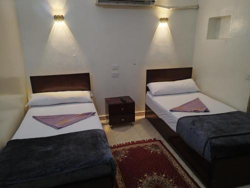 two beds in a small room with lights at NUBIAN MONALIZA guest house in Aswan