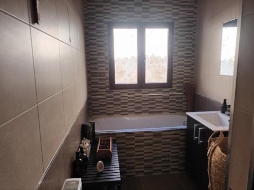 a bathroom with a tub and a sink and a window at Casa Laguna in Iznájar