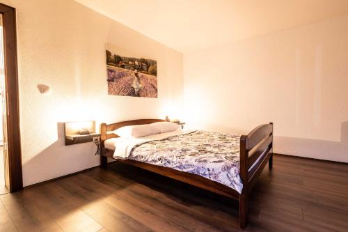 a bedroom with a bed and a painting on the wall at Lavender farm Zarić in Porosanica