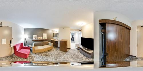 a living room with a couch and a living room with a room at Country Inn & Suites by Radisson, Winnipeg, MB in Winnipeg