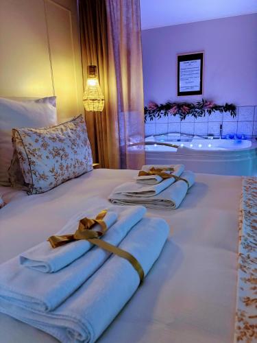 a bedroom with two towels on a bed with a tub at L'instant Beaujolais 2 ou 4 personnes Logis cosy balnéo vue jardin in Theizé