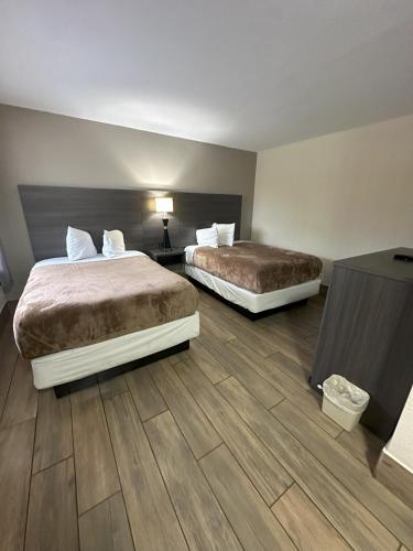 two beds in a hotel room with wooden floors at Econo Lodge St Petersburg Central in St. Petersburg
