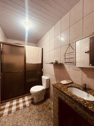 a bathroom with a toilet and a sink at Lar Doce Estadia in São Pedro da Aldeia