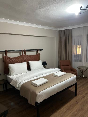 a bedroom with a large bed and a chair at Pera Line Yalova in Yalova