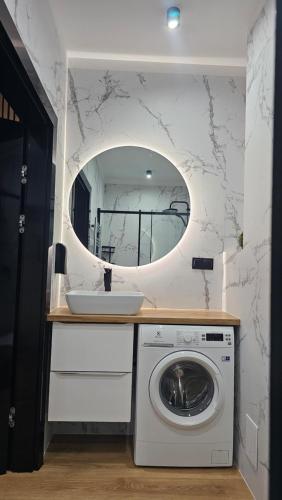a bathroom with a washing machine and a mirror at Anpol 1 idealny dla jednej osoby in Inowrocław