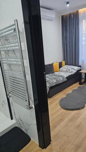 a living room with a bed and a stair case at Anpol 1 idealny dla jednej osoby in Inowrocław