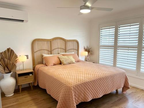 a bedroom with a bed and two lamps and a window at Ballina Oasis in Ballina