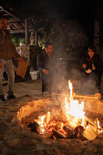 a group of people standing around a fire at Tierra Mia Hacienda Ruta del Vino in Valle de Guadalupe