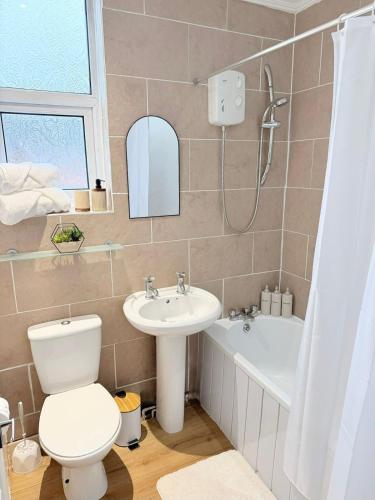a bathroom with a toilet and a sink and a bath tub at Deepdale House - Comfortable 2 Bedroom Home near Major Attractions in Preston in Preston