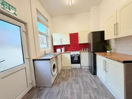 a kitchen with a washer and dryer in it at Deepdale House - Comfortable 2 Bedroom Home near Major Attractions in Preston in Preston