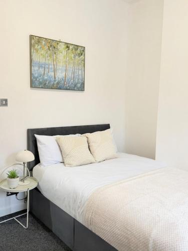 a bedroom with a bed and a picture on the wall at Deepdale House - Comfortable 2 Bedroom Home near Major Attractions in Preston in Preston
