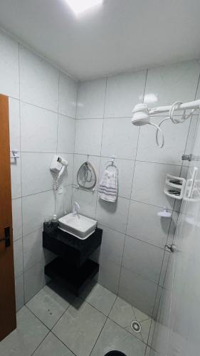 a bathroom with a sink and a glass shower at Vitallino Apartment | Modern with A/C, 10 min from the City Center in Caruaru
