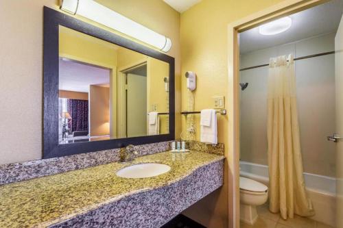 a bathroom with a sink and a toilet and a mirror at Quality Inn & Suites Baton Rouge West - Port Allen in Port Allen