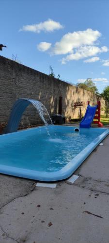 a blue pool with a water fountain at Pousada Mosselini in São Gabriel