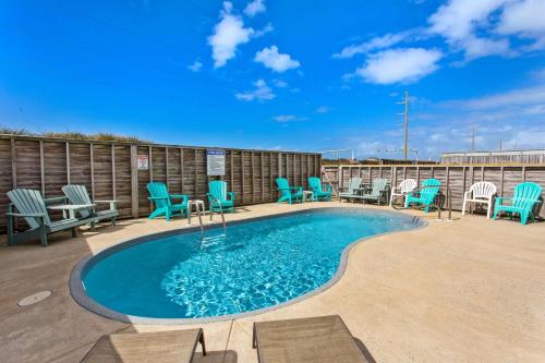 a swimming pool with blue chairs and a patio at 6150 - B Groove Inn (formerly Pelican Crest) in Nags Head
