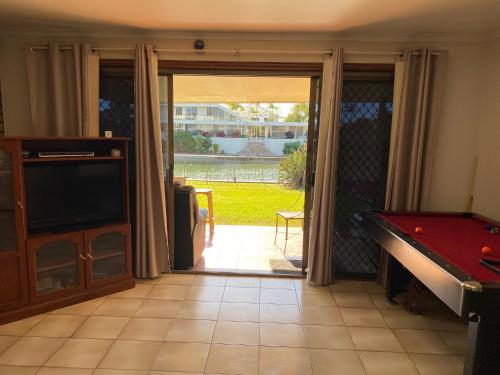 a living room with a pool table and a sliding glass door at Exclusive Sunrise Room, GC Blues Festival, Cool Autumn, Fire Pits, Fishing in Gold Coast