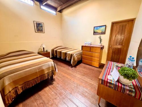 a hotel room with two beds and a dresser at La Casa de Isidora in Pan de Azúcar