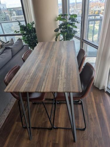 a wooden table and chairs in a room with a window at Nice Place Central to Downtown in St. Catharines