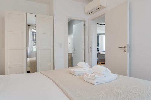 a bedroom with white towels on a bed at Bright 2BR Apartments in Funchal Centre, Walk Everywhere in Funchal