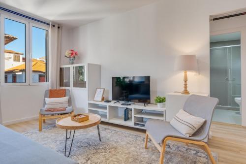 a living room with a bed and a table and chairs at Bright 2BR Apartments in Funchal Centre, Walk Everywhere in Funchal