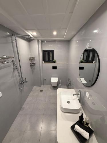 a white bathroom with a sink and a mirror at Serenity Residence Room Studio 1BHK in Rachiāl