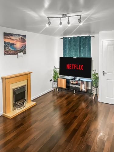 a living room with a television and a fireplace at New Manchester City Getaway House with 2 FREE Parking in Manchester
