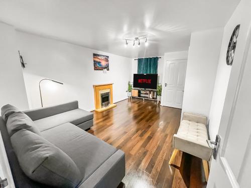 a living room with a couch and a tv at New Manchester City Getaway House with 2 FREE Parking in Manchester
