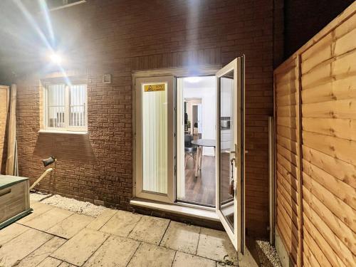 a room with a glass door in a brick wall at New Manchester City Getaway House with 2 FREE Parking in Manchester