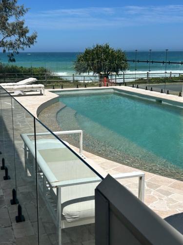 a swimming pool with a view of the ocean at Saltwater Apartments in Lake Cathie