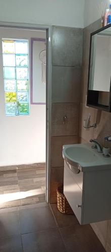 a bathroom with a sink and a television on the wall at Casa Sol Naciente in Villa Santa Cruz del Lago